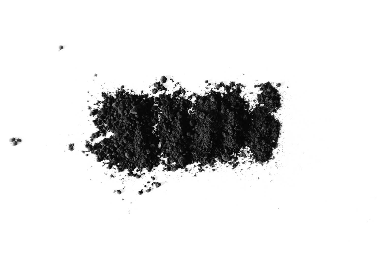 Poudre noire dispersée sur fond blanc