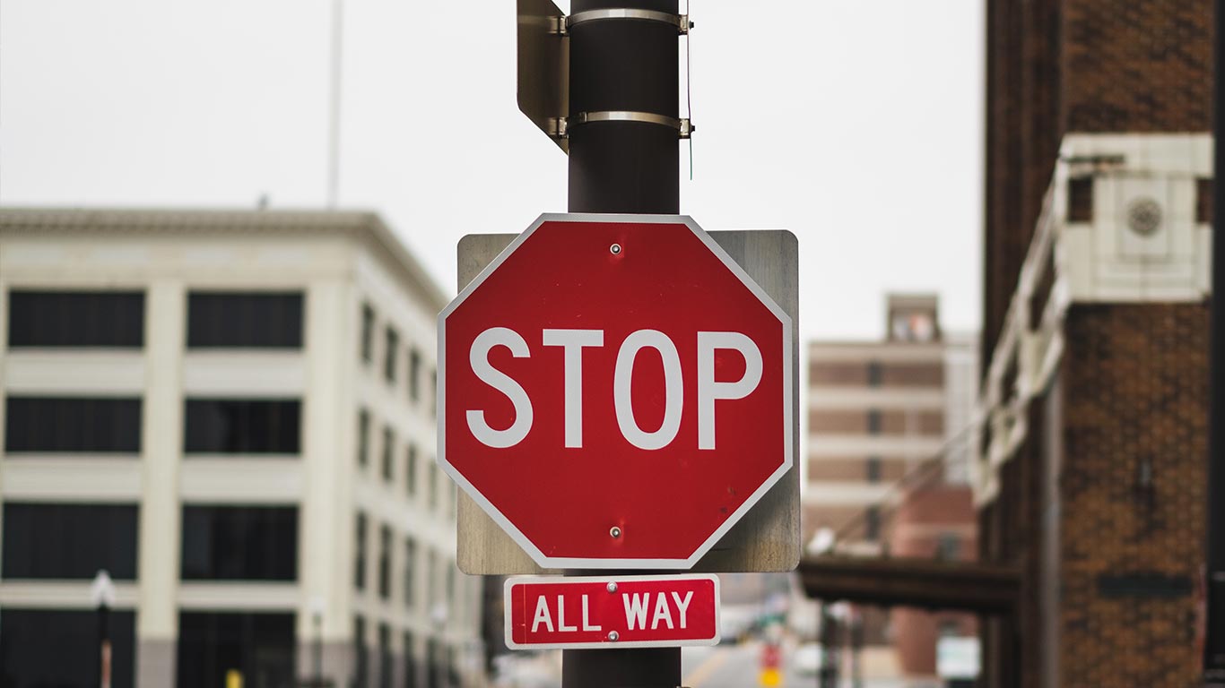 Panneau d'arrêt rouge indiquant "STOP" et "ALL WAY" dans une zone urbaine
