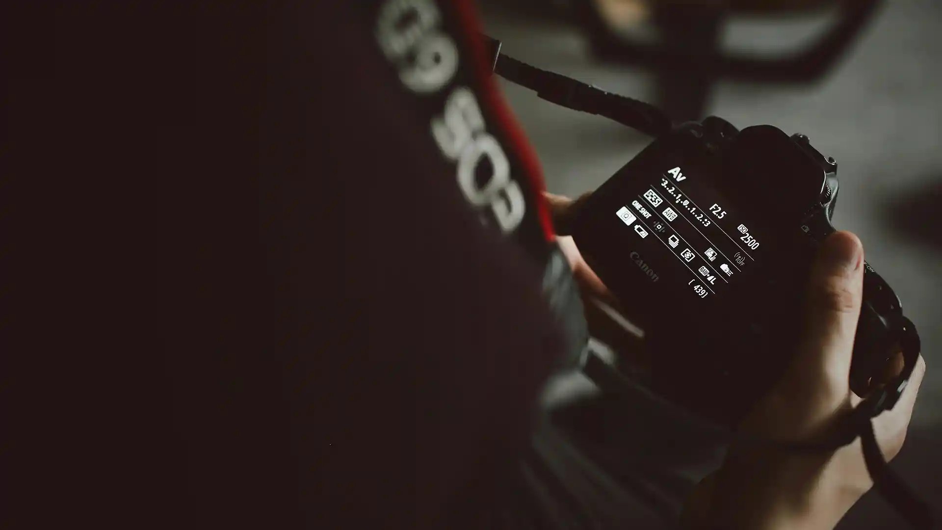 Photographe ajustant les paramètres d'un appareil photo Canon en mode faible luminosité