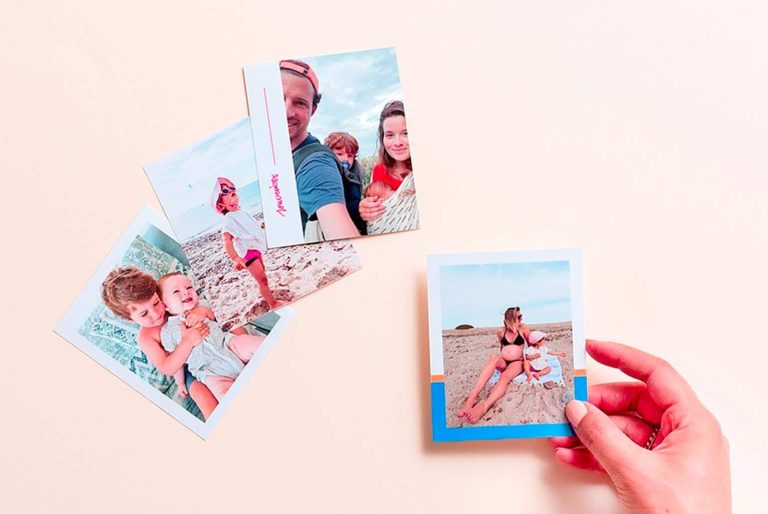 Quatre photos de famille sur une table avec une main tenant l'une d'elles.