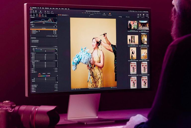 Édition de photo sur un écran d'ordinateur avec un appareil photo à côté.
