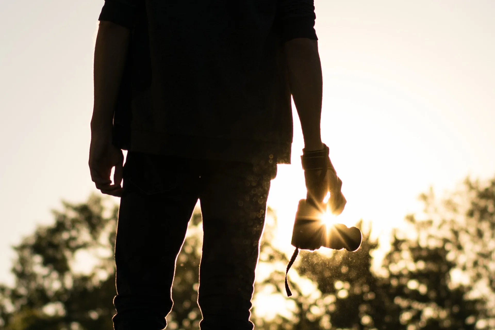 Photographe en silhouette au coucher du soleil, appareil photo à la main