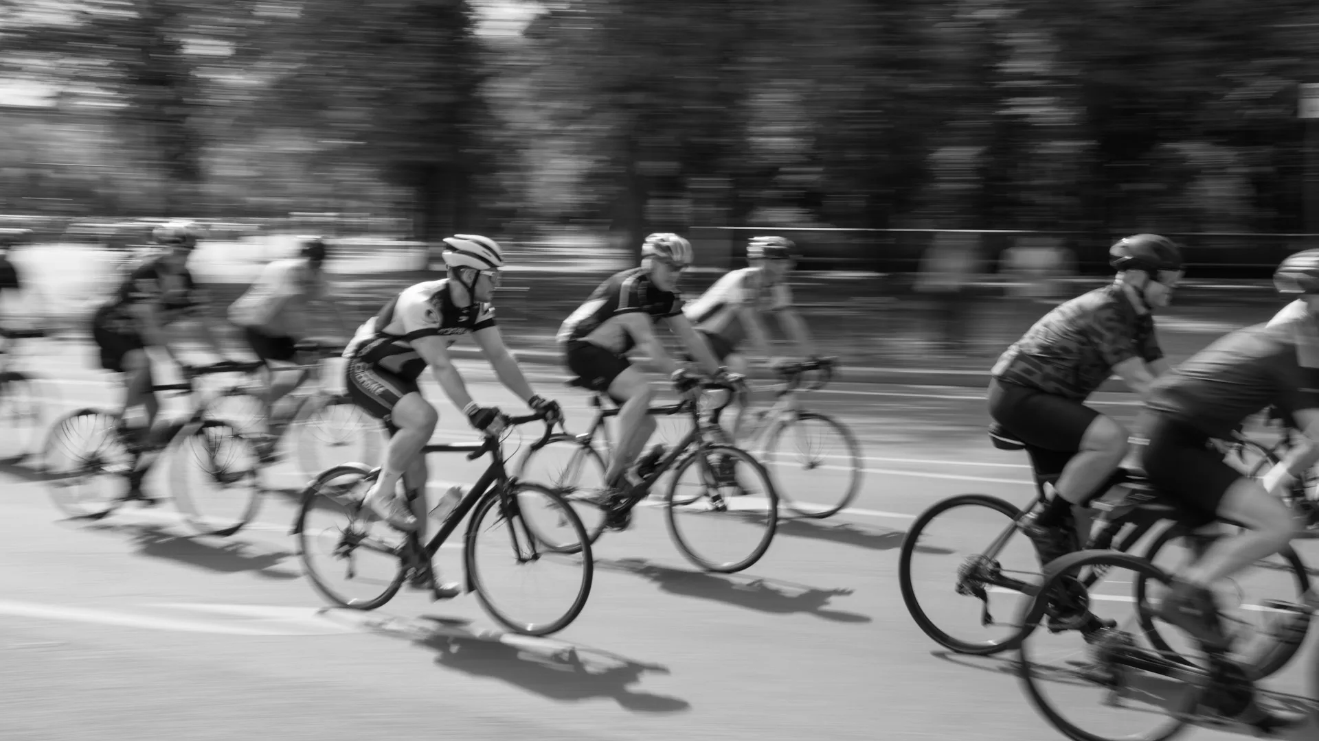 Filé de cyclistes en course, arrière-plan strié par le mouvement de l'appareil