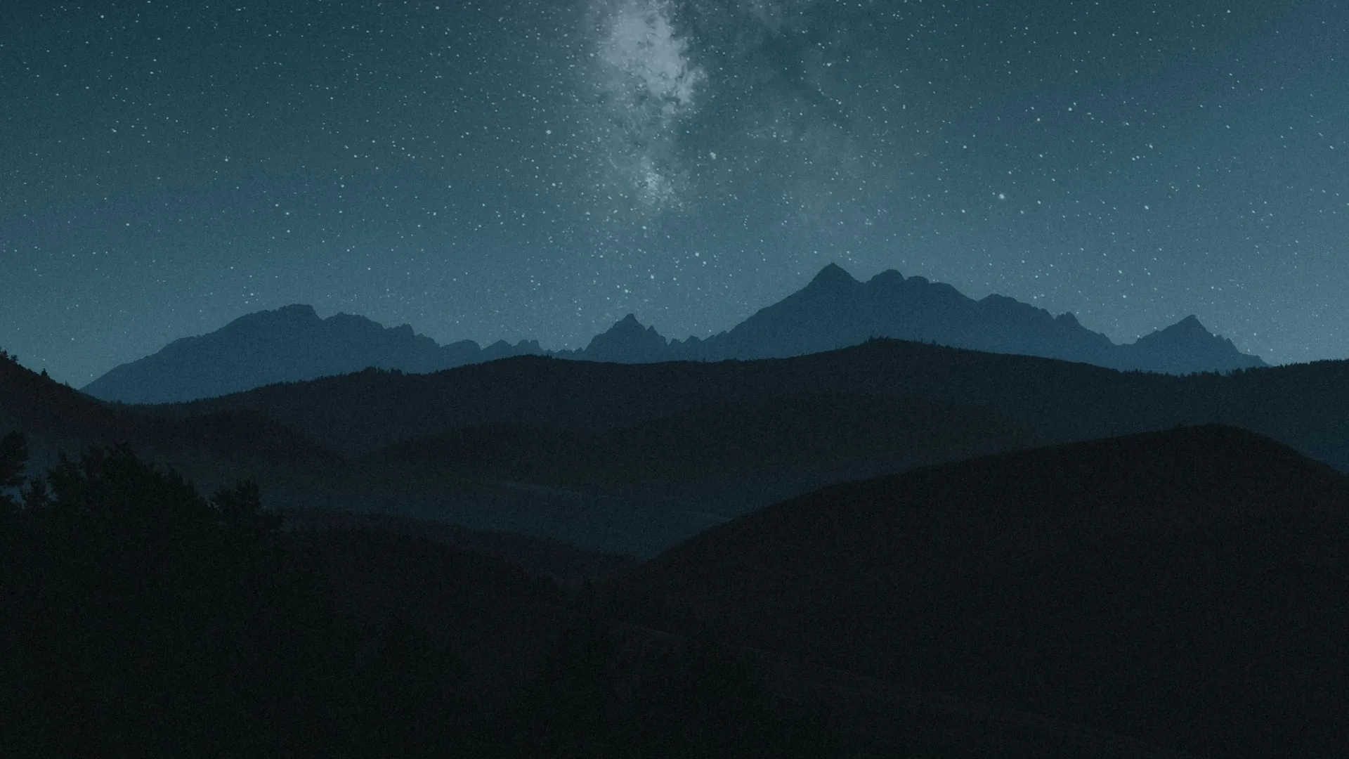 Voie lactée au-dessus de montagnes en silhouette, ciel étoilé sans lune