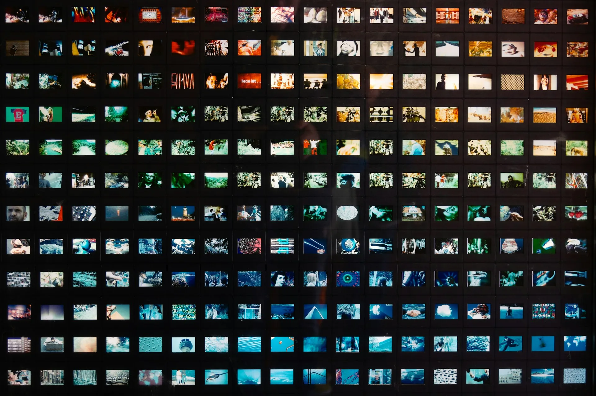 Mur de diapositives rétroéclairées formant une grille de centaines de photos à retrouver