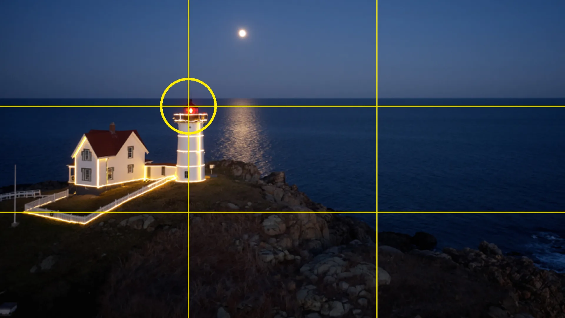 Phare illuminé la nuit avec grille de la règle des tiers : la lanterne est posée sur l'intersection du tiers gauche et du tiers haut
