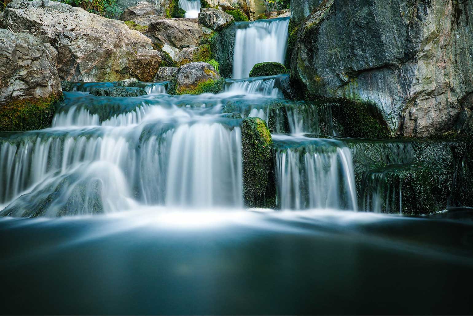 Cascade d'eau naturelle entourée de rochers et de mousse luxuriante